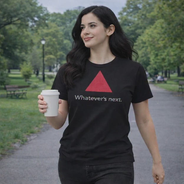 Model wearing black tee, walking in the park.