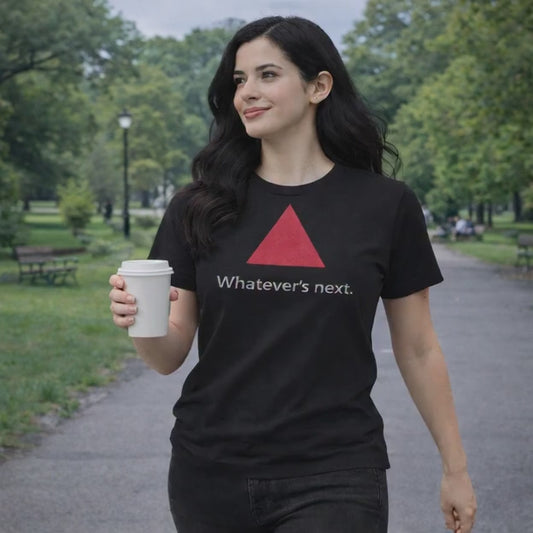 Model wearing black tee, walking in the park.